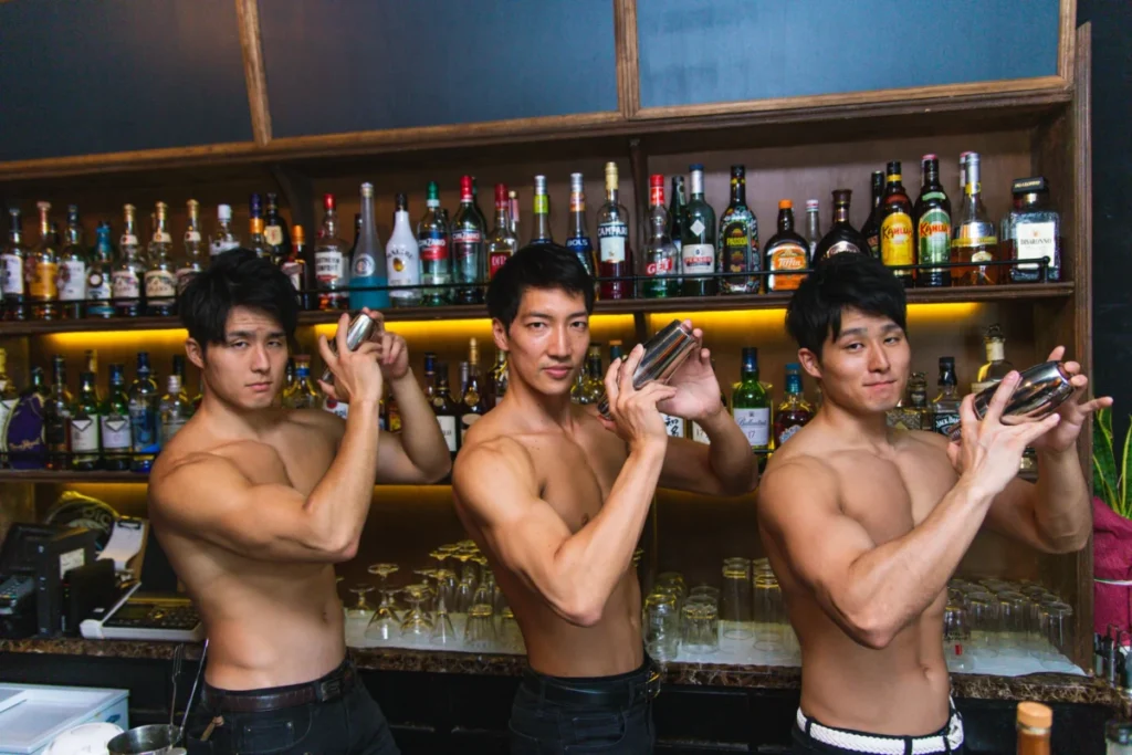 Muscle bar in Tokyo with muscular male bartenders performing cocktail service