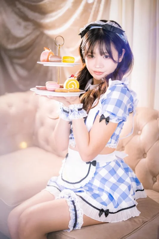 Maid style concafe staff holding dessert tray in a themed Japanese concept cafe environment