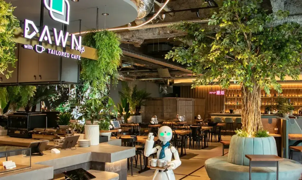 スクリーンショット 2026-01-04 18.36.04 Atmosphere inside DAWN Avatar Robot Cafe featuring greenery, seating area, and avatar robots