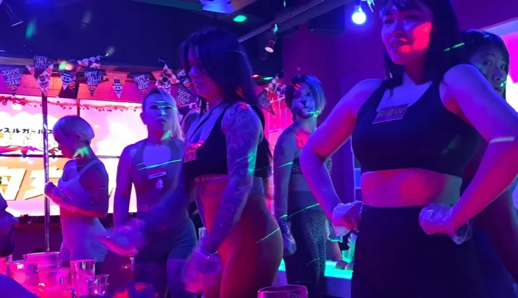 Inside a muscle girls bar in Tokyo with energetic staff and nightclub lighting