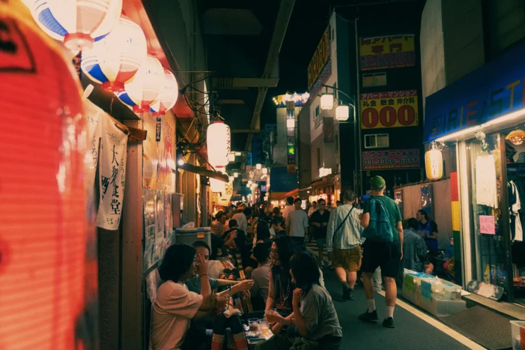 ayumi-kubo-w19uQvjfvA0-unsplash Crowded izakaya street in Japan at night with locals drinking and socializing