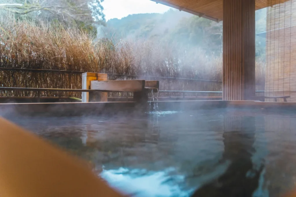 Outdoor onsen in Japan with steam rising in a quiet setting