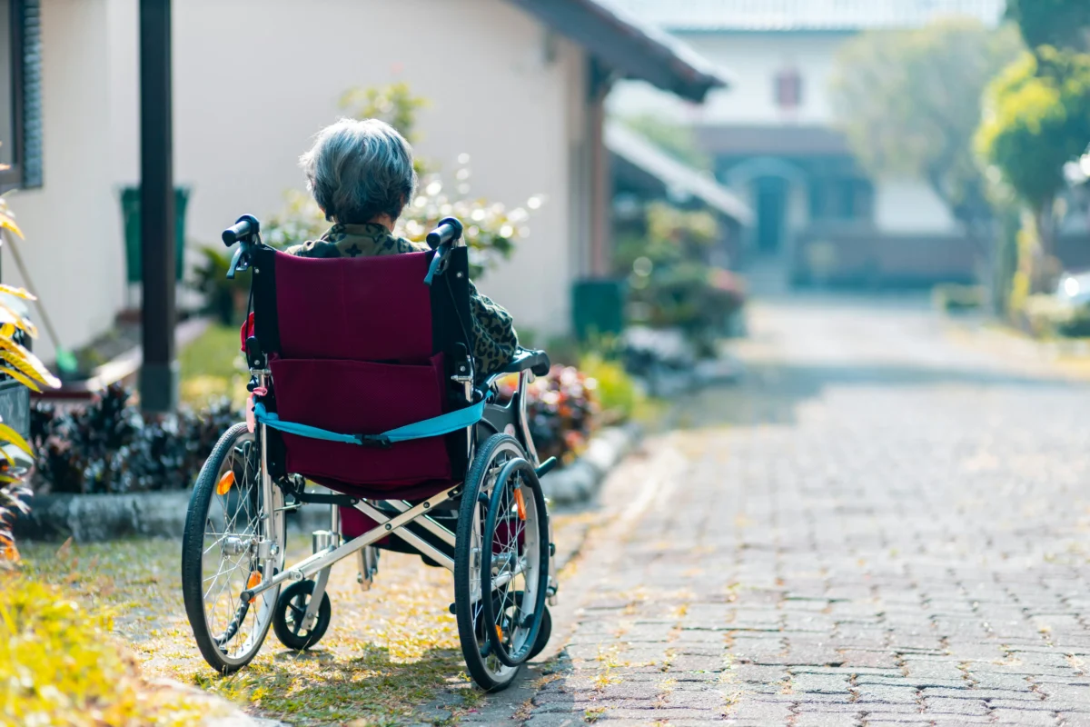 steven-hwg-zBsdRTHIIm4-unsplash Senior person using a wheelchair on a residential street in Japan