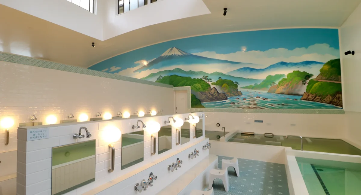 Japanese sento washing area with mirrors and scenic wall art