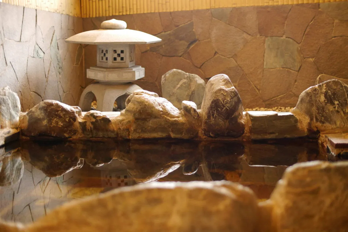 Traditional Japanese onsen rock bath with hot spring water