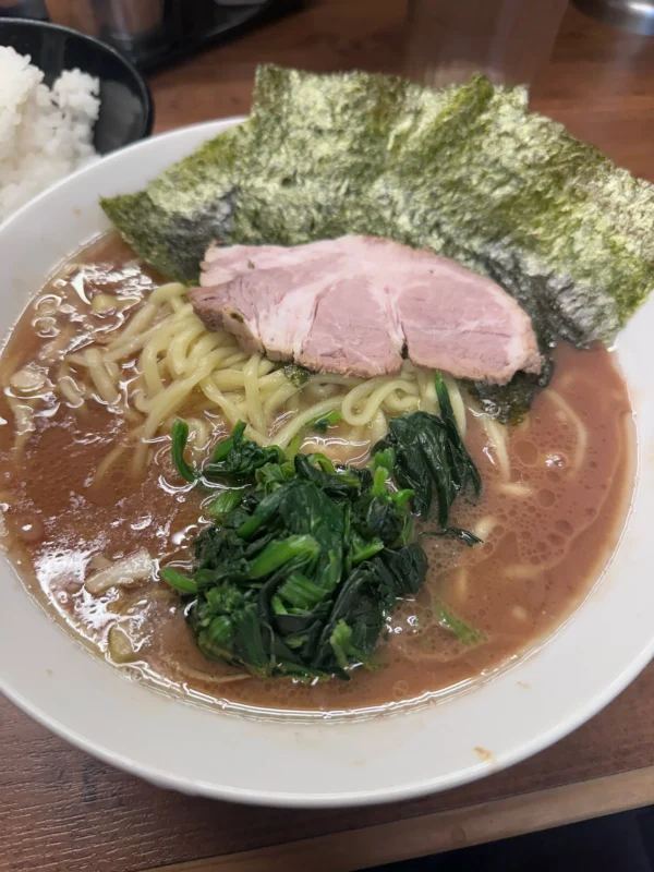 Iekei ramen served with white rice, nori, spinach, chashu, and thick noodles