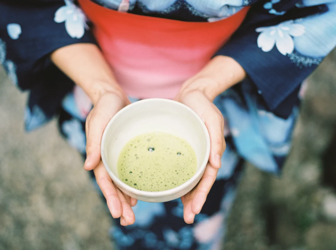 motoki-tonn-tJ6GNCJ1gyM-unsplash Person holding a bowl of matcha during a Japanese tea ceremony
