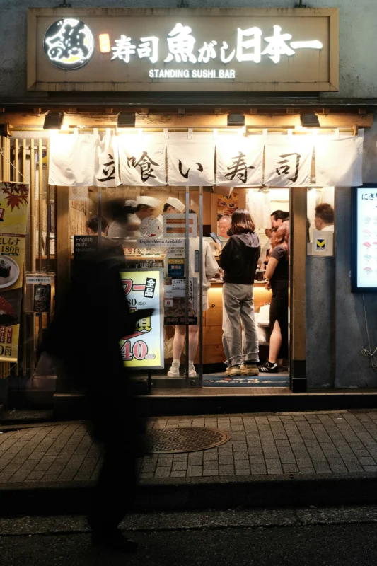 Standing sushi restaurant in Shibuya with customers dining at night