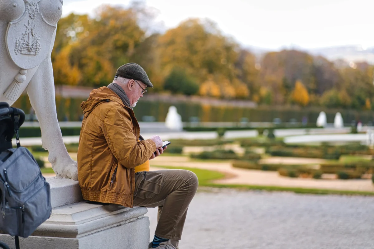 anthony-lIPGxr52Ccg-unsplash Senior traveler resting in a garden during a sightseeing trip