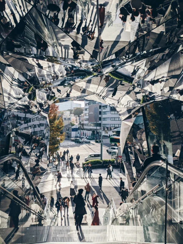 note-thanun-EauT7hRPi5I-unsplash People walking through a mirrored urban space in Tokyo