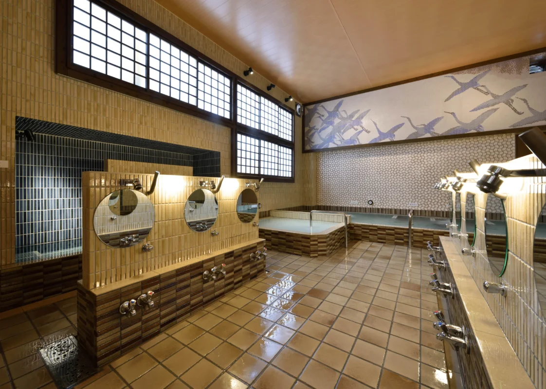 washroom Japanese sento washing area with mirrors, showers, and shared baths at Mannenyu