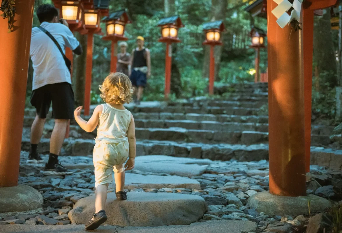 gavin-li-YZqK41-EsZE-unsplash Young child walking through a shrine area in Kyoto