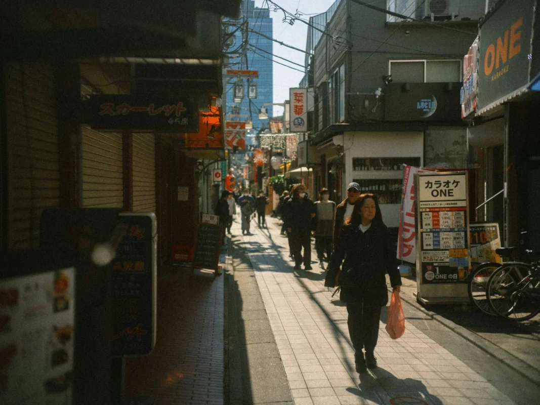 People walking along a narrow shopping street in Tokyo