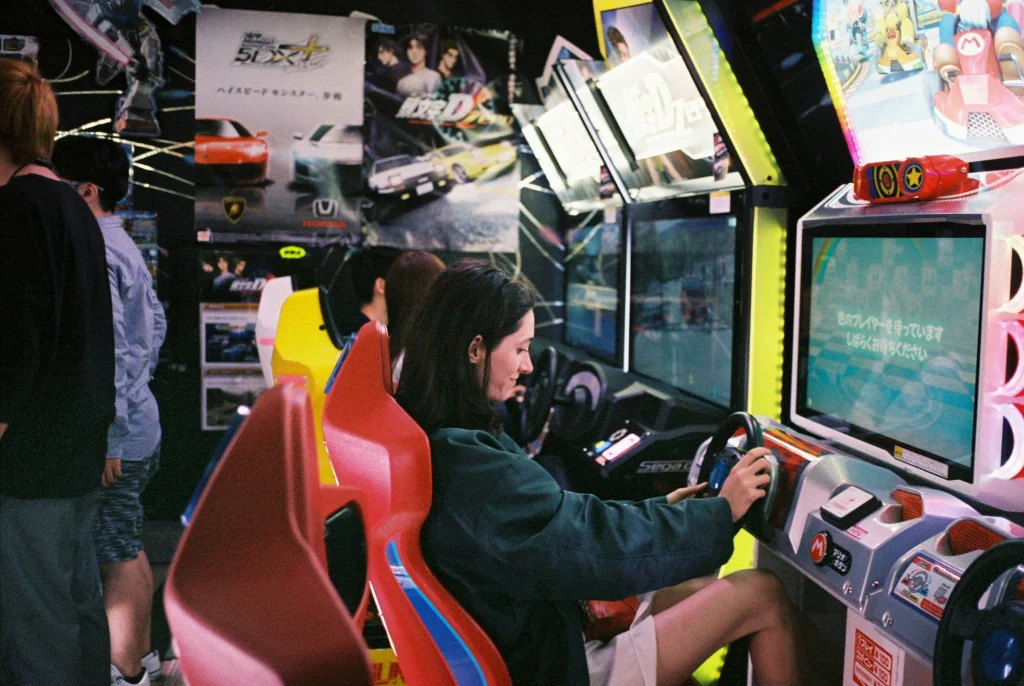 Woman playing a racing game at a Japanese arcade