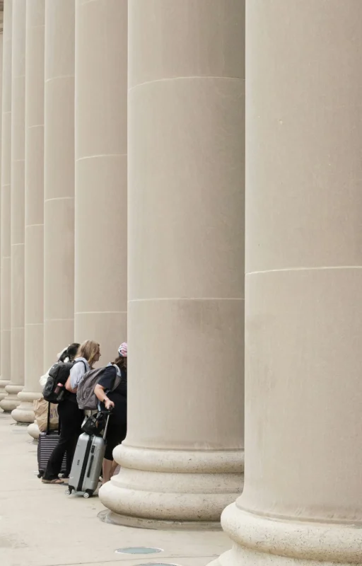 matthew-jackson-Pyo-NwBEEBg-unsplash Travelers with luggage outside a large public building