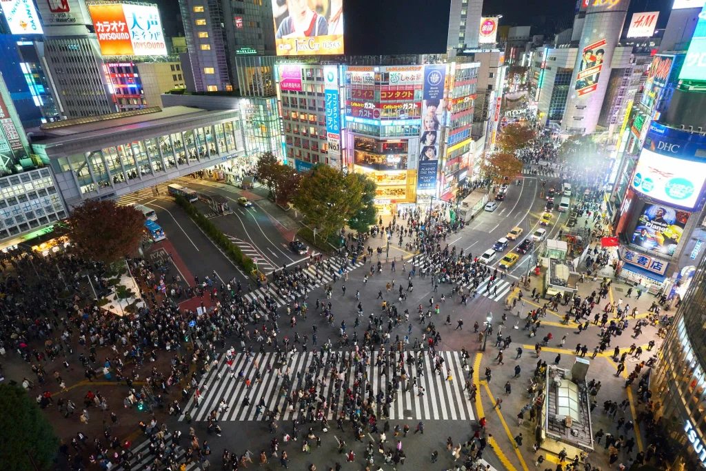 Shibuya Crossing filled with pedestrians at night