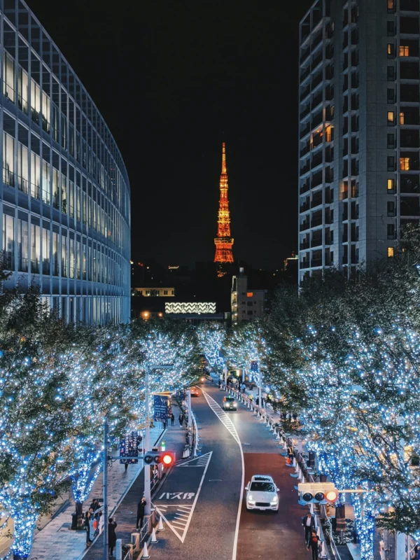 note-thanun-dOFpWEml0nw-unsplash (1) Tokyo Tower illuminated at night, viewed from a street lined with decorative lights